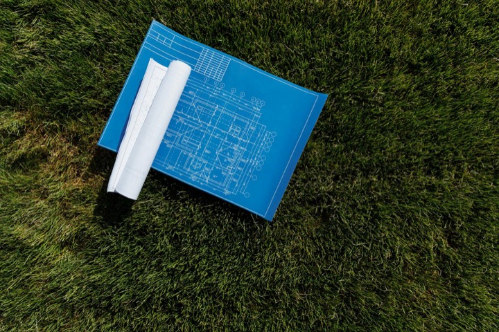 Landscape design plan with measuring tape on grass