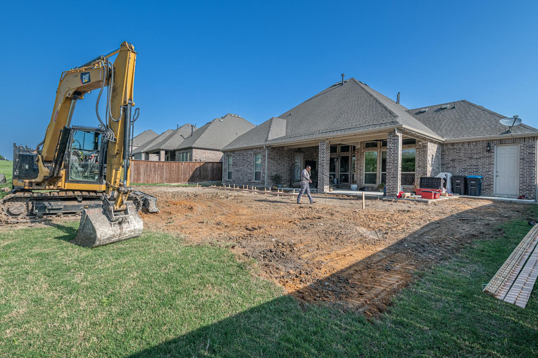 A bare dirt backyard under construction before landscaping